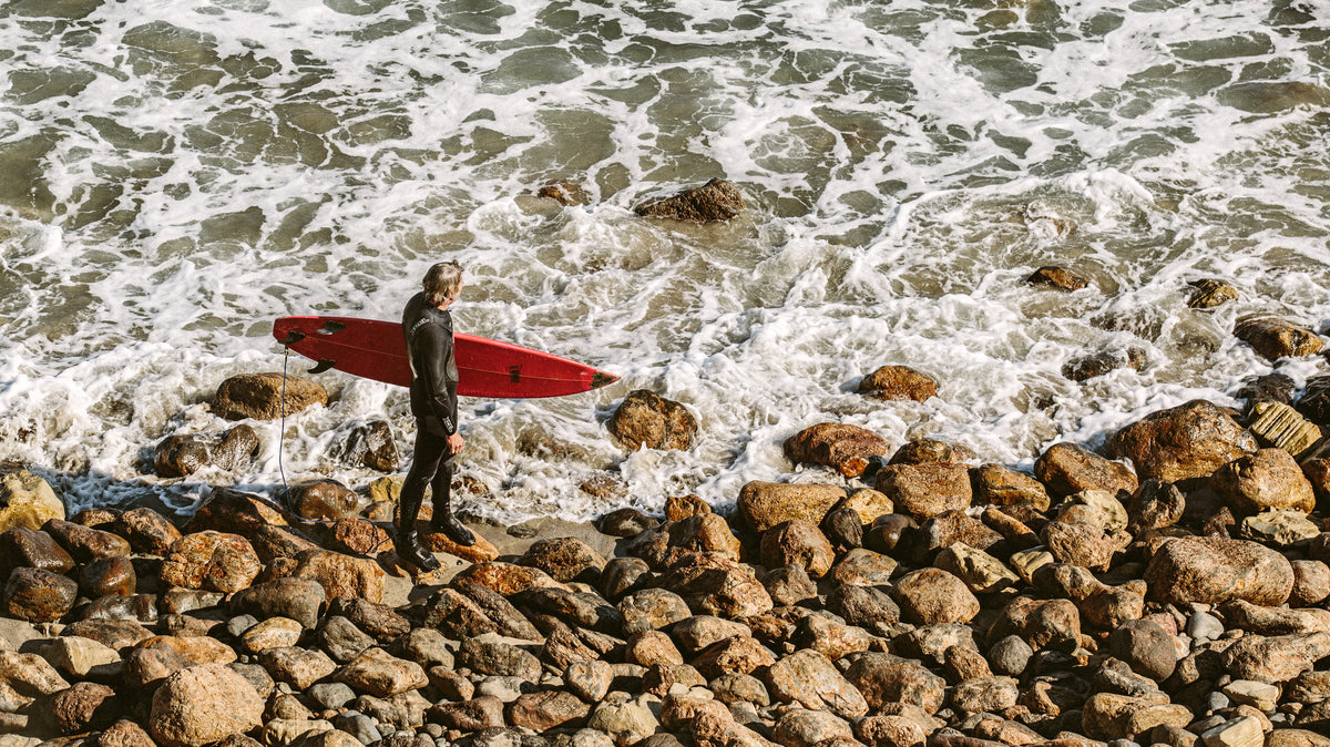 Surfista observando el mar antes de una sesión en Point Dume, Malibu; fotografía real de Vladimir Kudinov usada en THE SURF TOWN JOURNAL