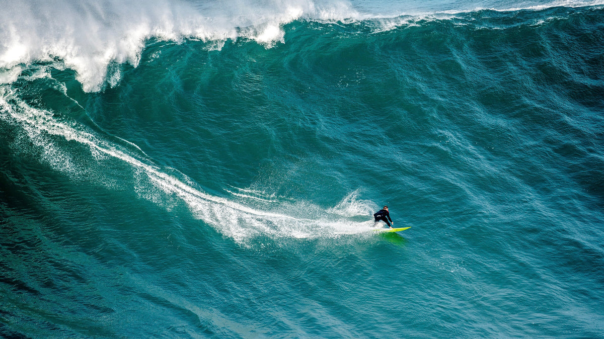 Surfista frente a una ola gigante en Nazaré, escenario clave de los Big Wave Challenge 2026