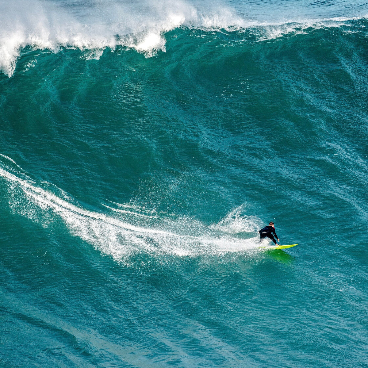 Surfista frente a una ola gigante en Nazaré, escenario clave de los Big Wave Challenge 2026