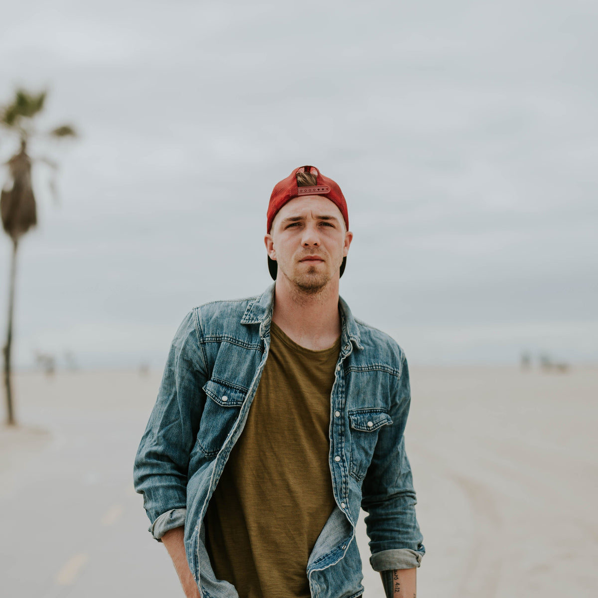 Hombre con prenda vaquera en Venice Beach, fotografía real para guía de camisas y sobrecamisas de otoño de THE SURF TOWN JOURNAL. Foto: Brooke Cagle / Wikimedia Commons, CC0.