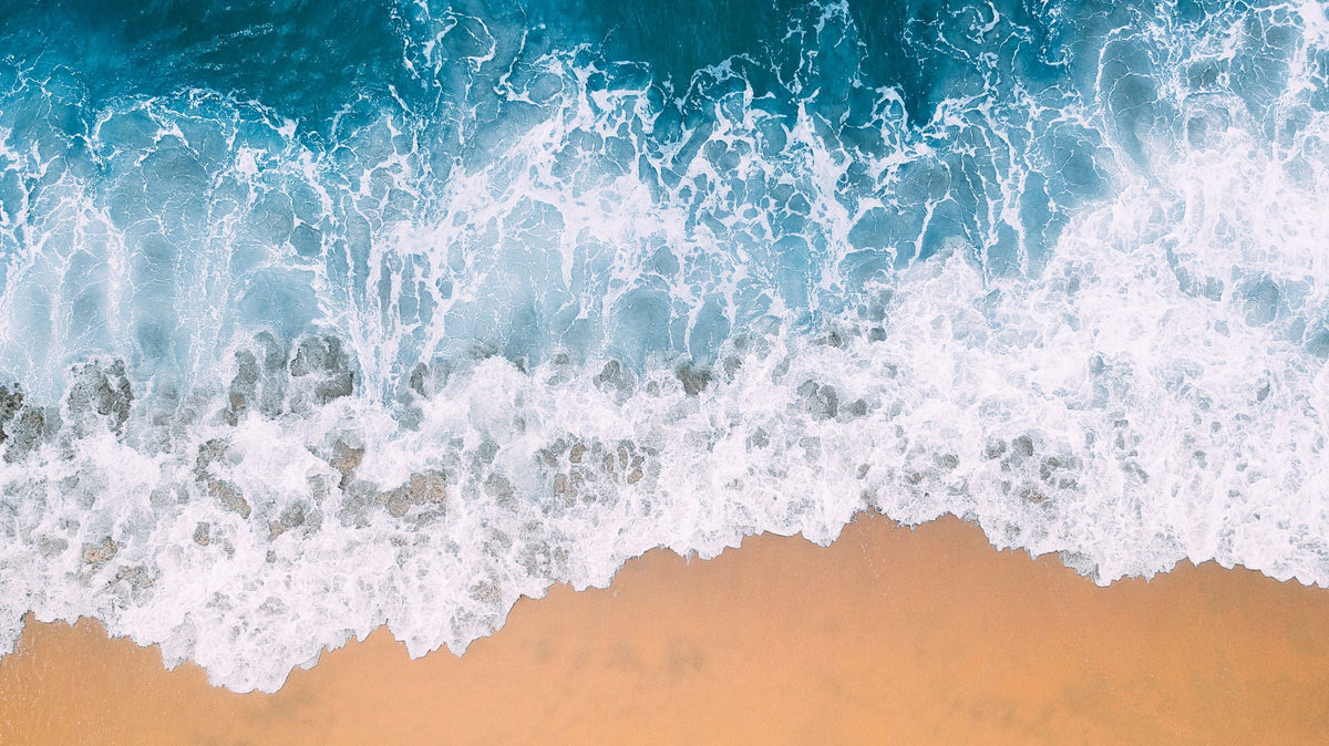 Vista aérea de olas y canales de agua junto a una playa