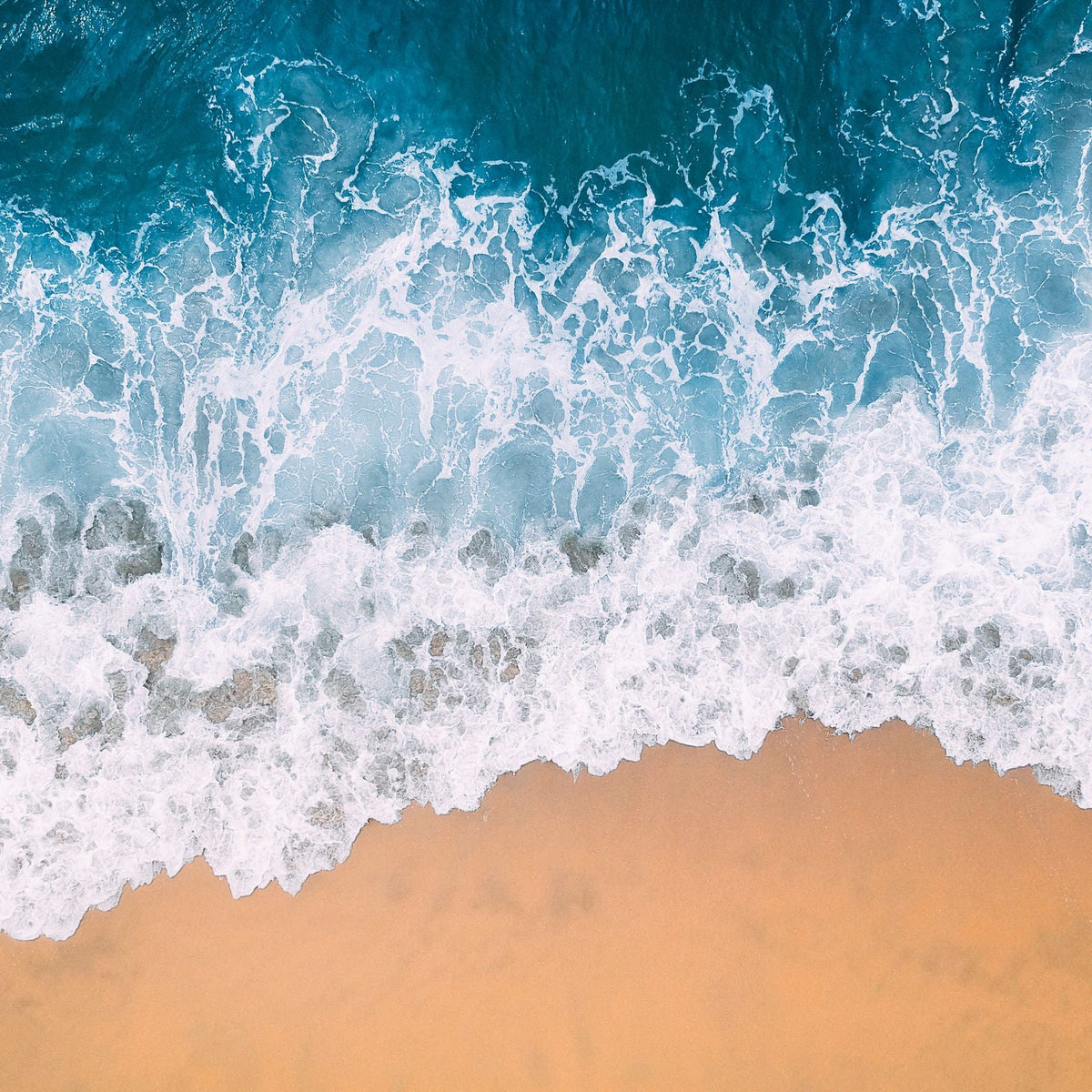 Vista aérea de olas y canales de agua junto a una playa