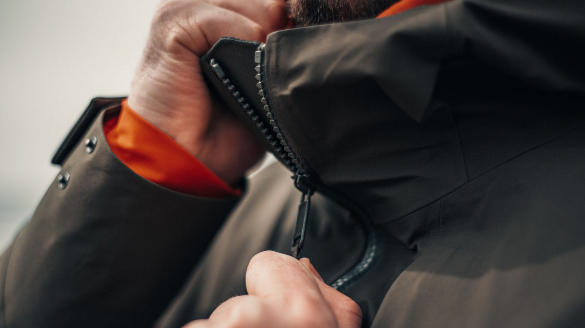 Una persona cierra la cremallera de una chaqueta en el exterior