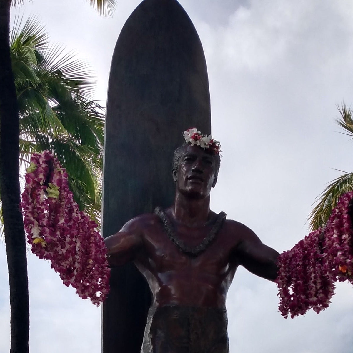 Duke Kahanamoku sobre una tabla de surf en fotografía histórica