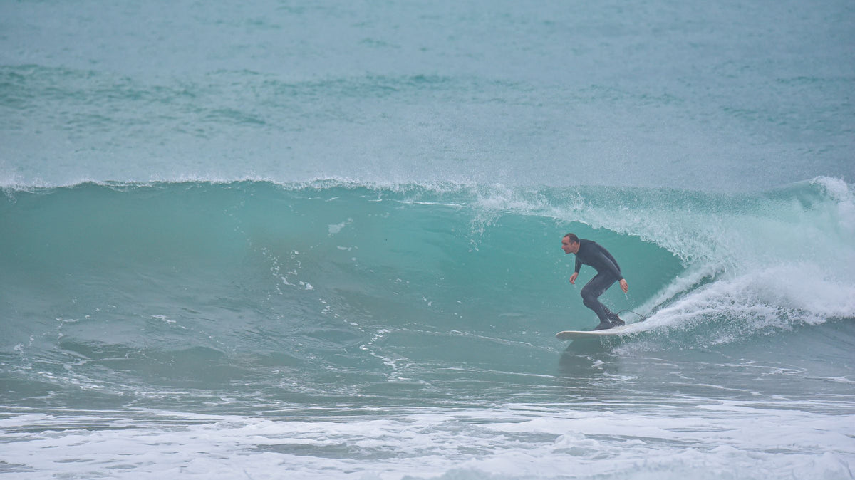 Surfista avanzando por el interior de una ola tubular