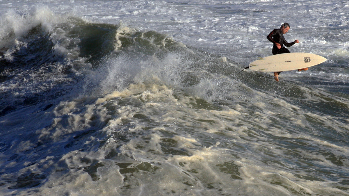 Surfista durante una caída en una ola de Santa Cruz, California