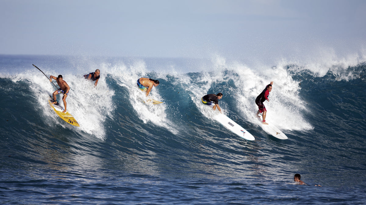 Varios surfistas comparten una ola amplia en Paea, Tahití