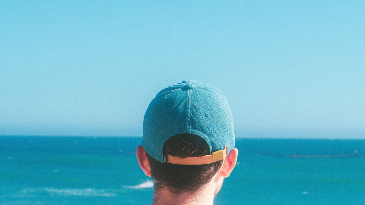 Gorra real frente al mar, portada horizontal de guía de gorras surferas
