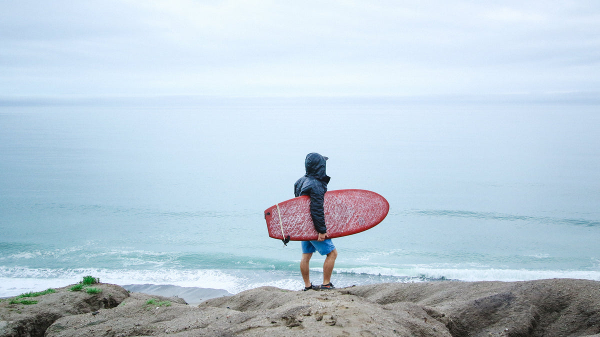 Surfista con capucha de neopreno frente al mar en San Clemente