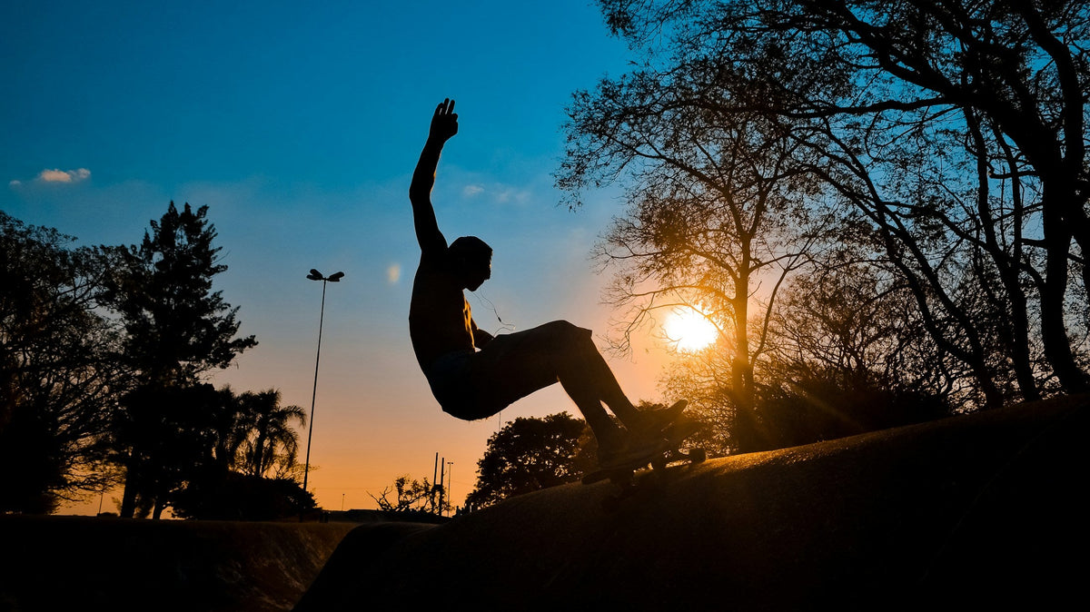 Skater en silueta realizando una maniobra al atardecer, portada real del artículo de entrenamiento con surfskate