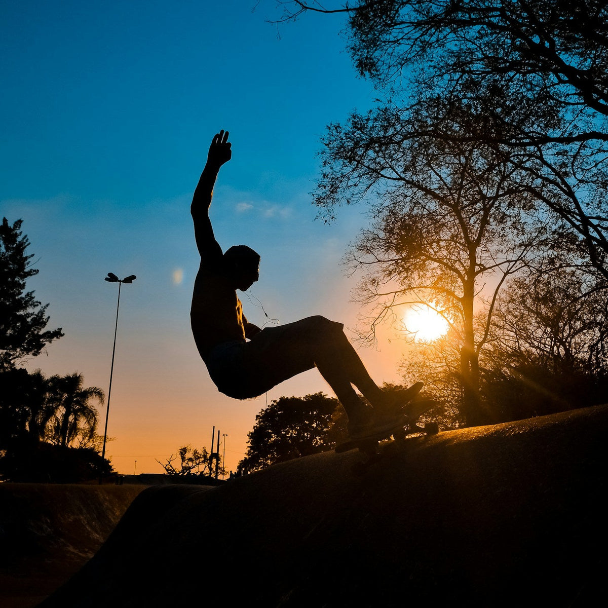 Skater en silueta realizando una maniobra al atardecer, portada real del artículo de entrenamiento con surfskate