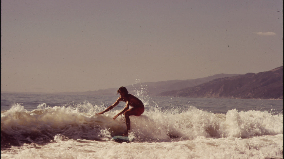 Surfista con longboard en una ola de Malibu en 1972