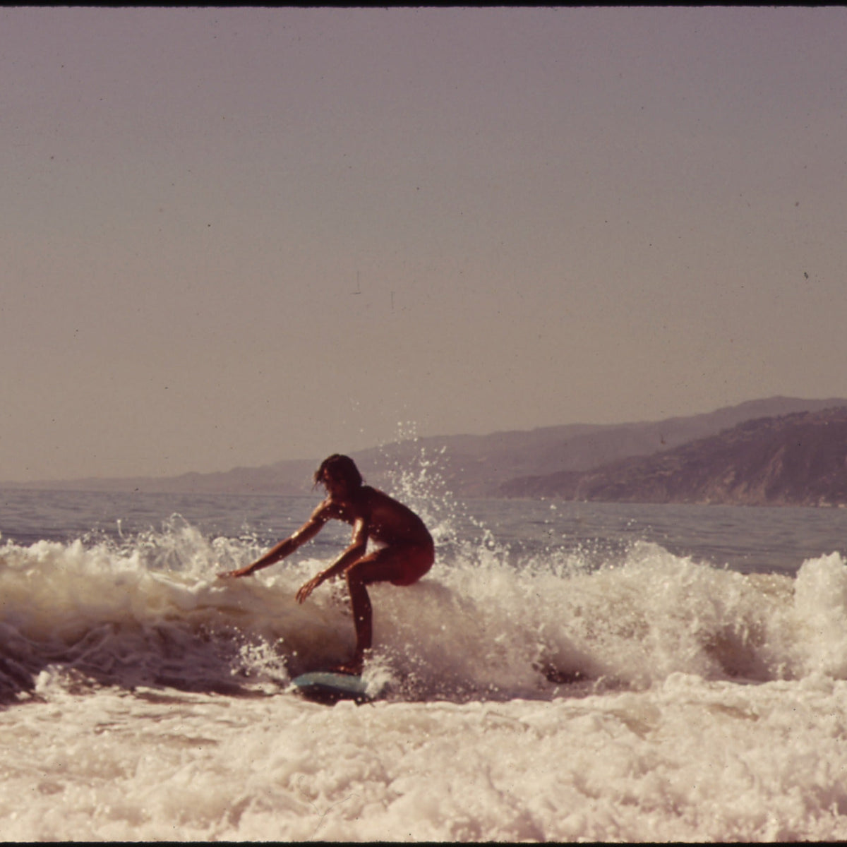 Surfista con longboard en una ola de Malibu en 1972
