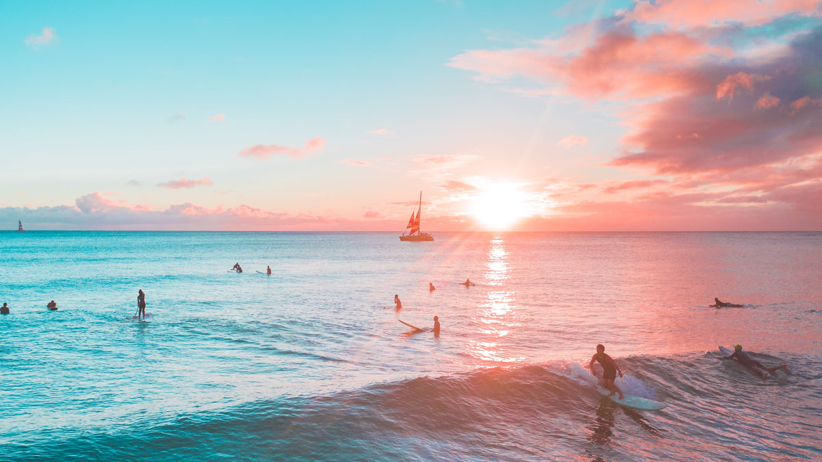 Surfistas en el mar al atardecer durante una sesión de surf