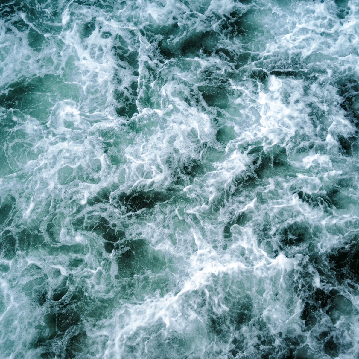 Series de olas avanzando hacia la costa vistas desde un muelle