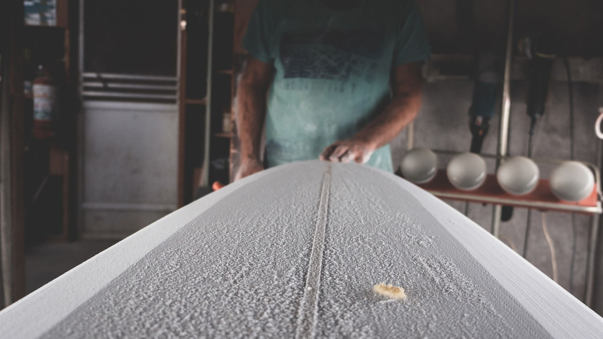 Shaper trabajando sobre un blank de surf en un taller