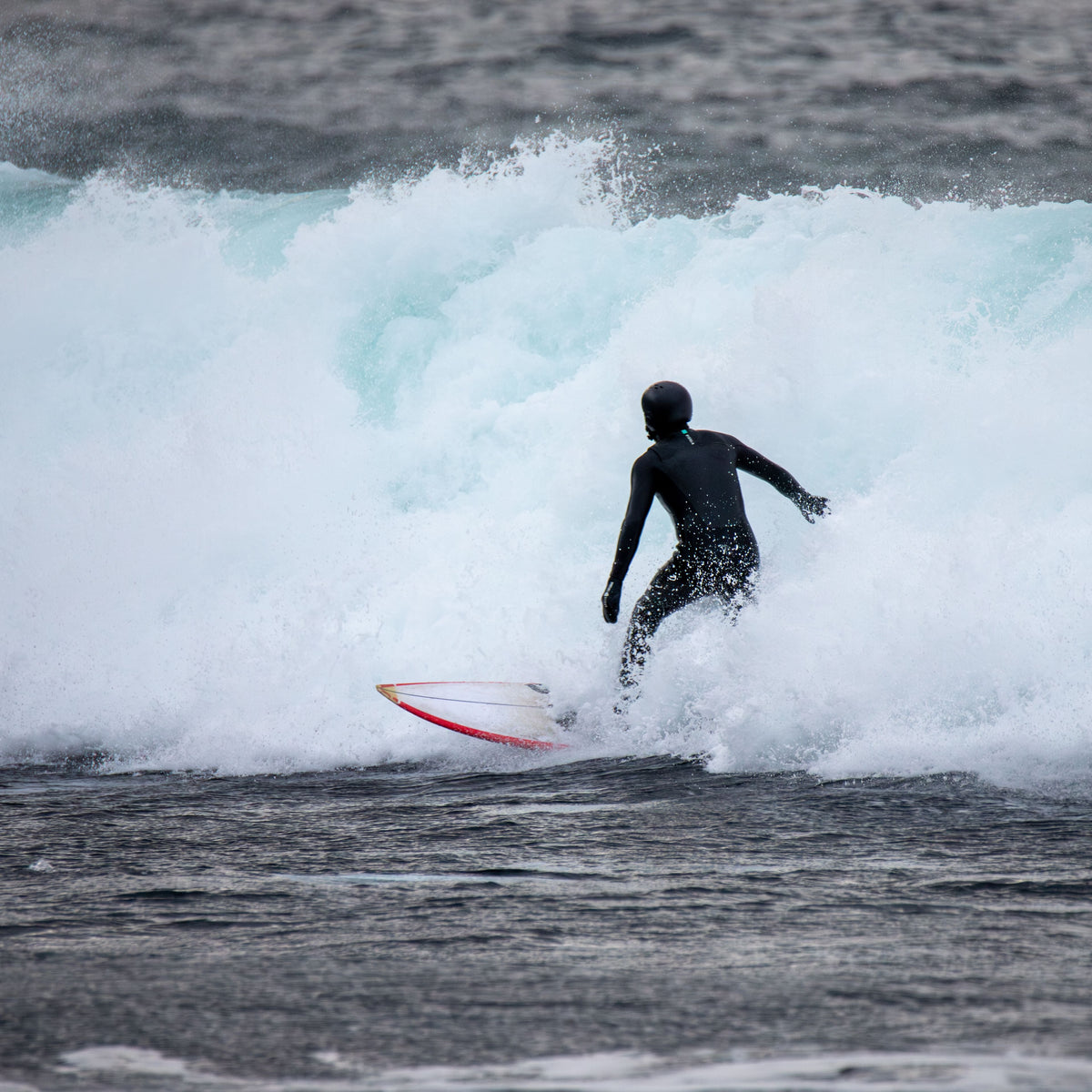 Surfista con neopreno en olas frías de invierno en Noruega