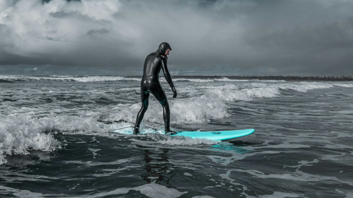 Surfista en el agua bajo un cielo cubierto después de la lluvia