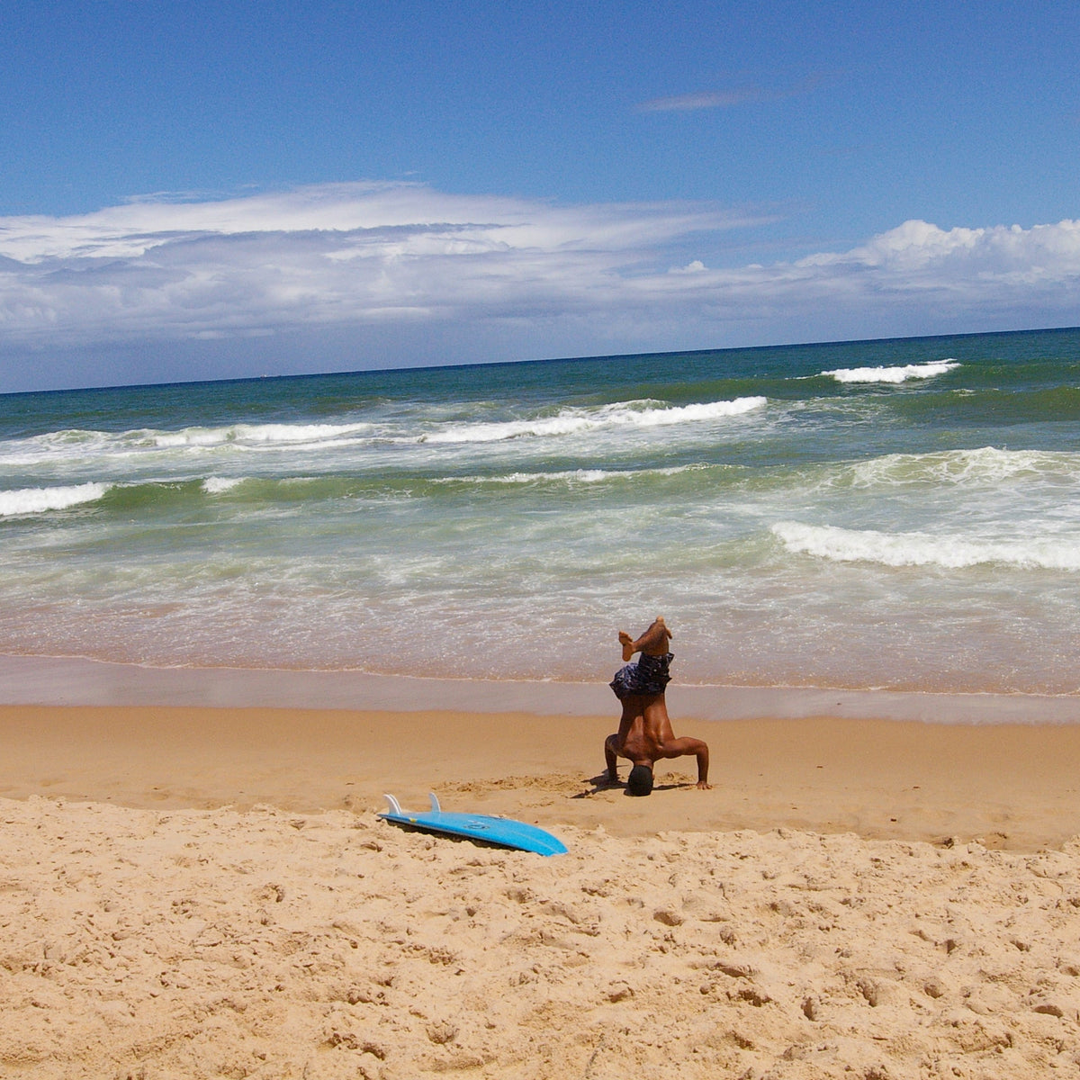 Surfista realizando un calentamiento dinámico en una playa de Bahía antes de entrar al agua