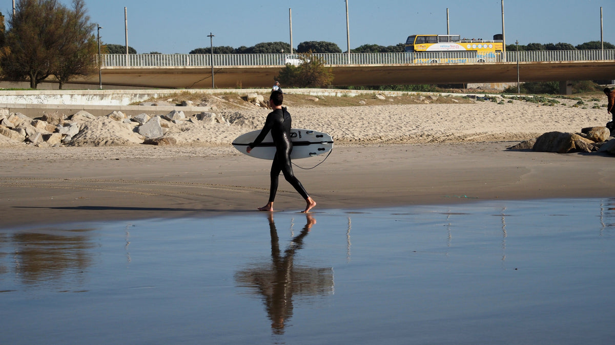 Surfista en la playa de Matosinhos después de una sesión, contexto para cambiarse con un poncho de surf