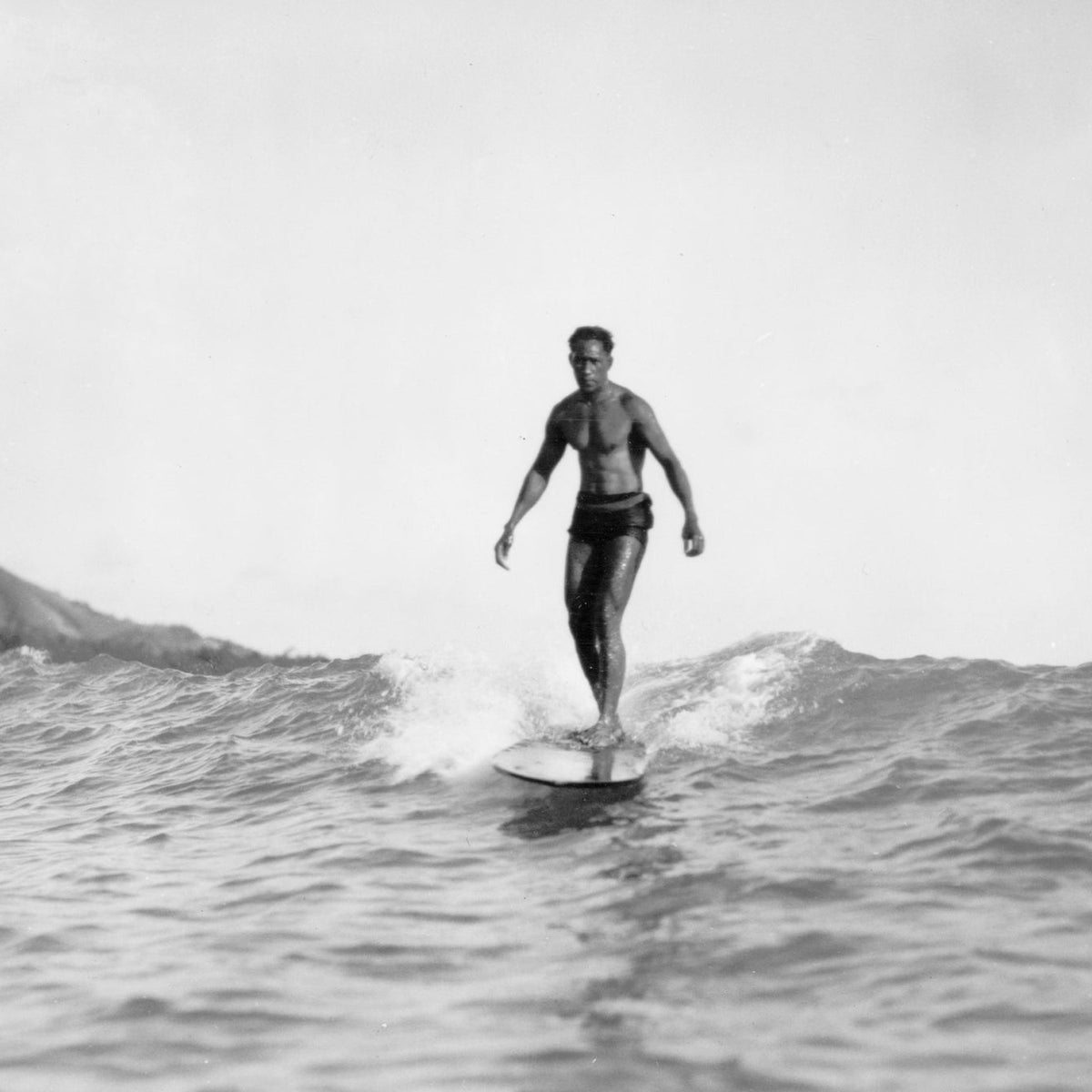 Surfista en una ola de Honolulu en 1929, contexto histórico de las innovaciones de Tom Blake