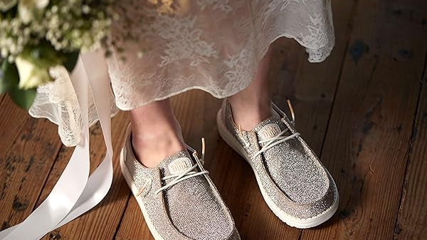 mujer cambiando tacones por zapatillas HEY DUDE en boda para bailar cómoda
