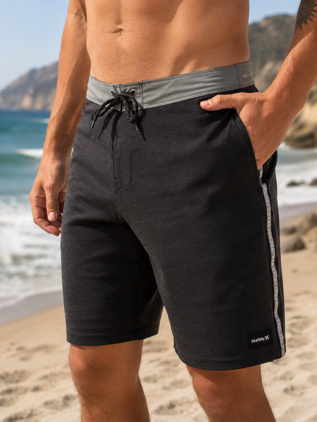 Bañador Hurley Phantom Hybrid negro y marrón para hombre en entorno lifestyle surf y playa mediterránea