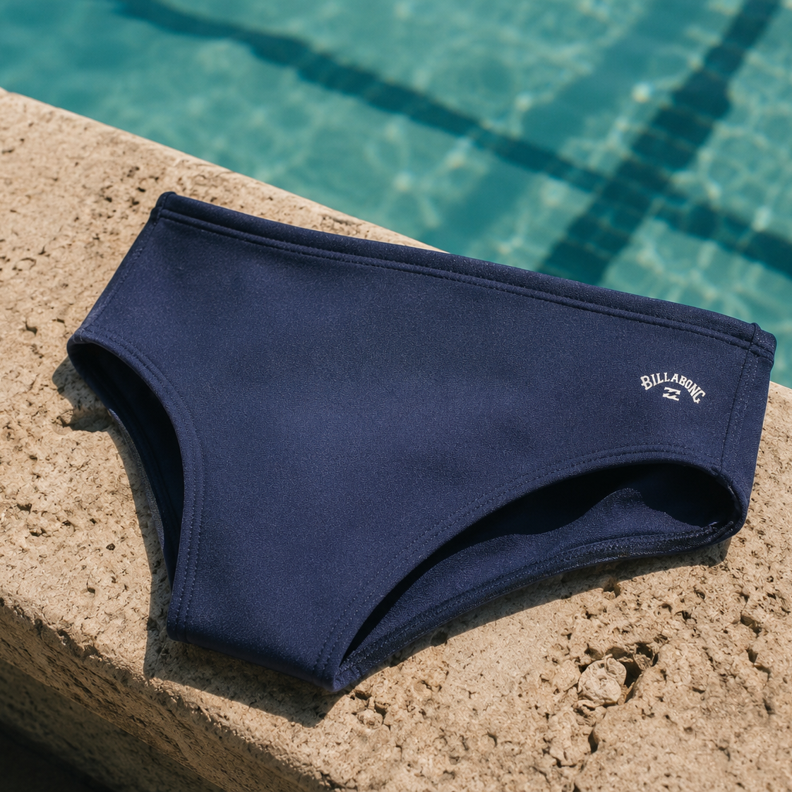 Bañador de natación Billabong Fontana Navy apoyado junto a piscina premium con diseño azul marino y estética verano lifestyle