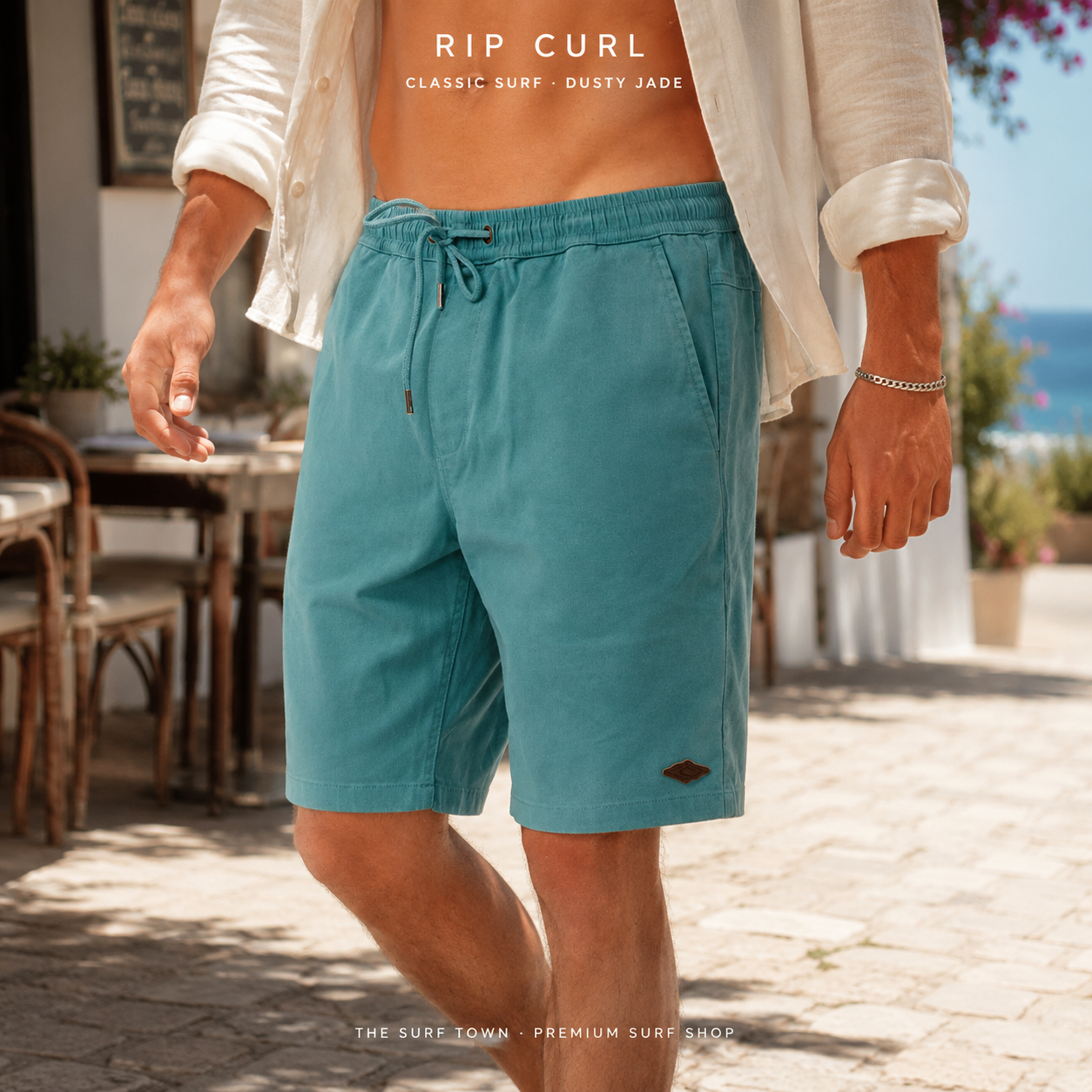 Bermudas Rip Curl Classic Surf 19 Volley Dusty Jade para hombre en un paseo mediterráneo junto al mar, imagen editorial propia de THE SURF TOWN.