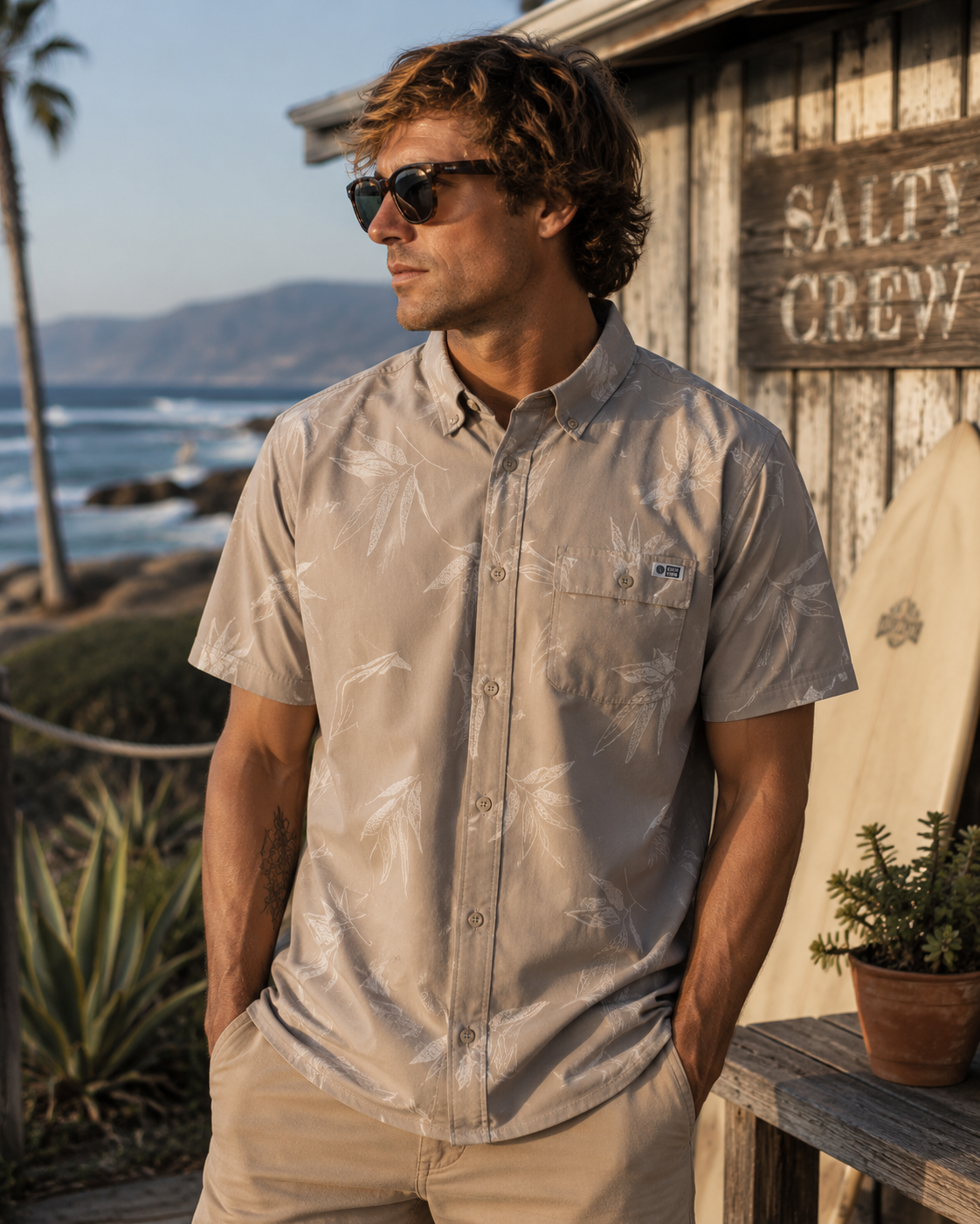 Camisa hombre microperforada Salty Crew color dark khaki en entorno surf shack premium junto al mar estilo lifestyle Costa del Sol