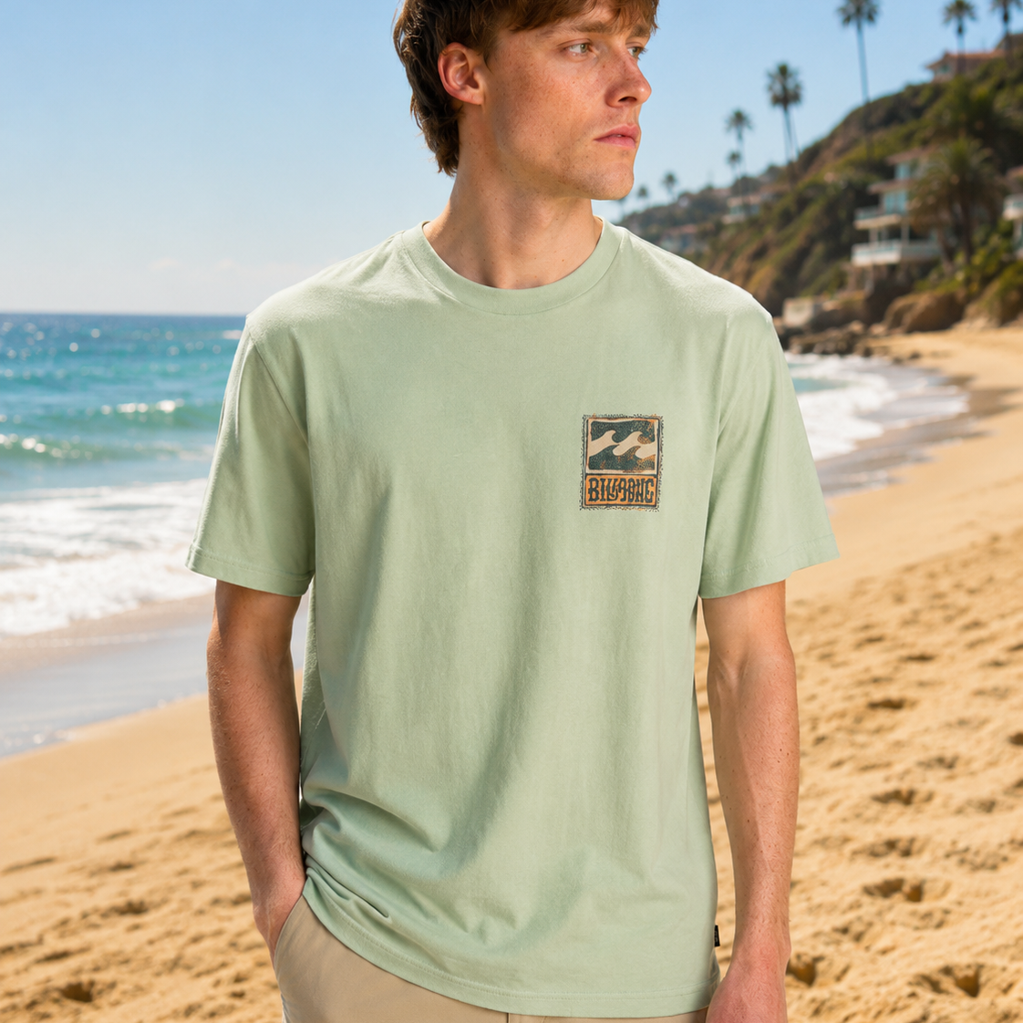 Camiseta Billabong verde hombre estilo surf premium en playa soleada frente al mar