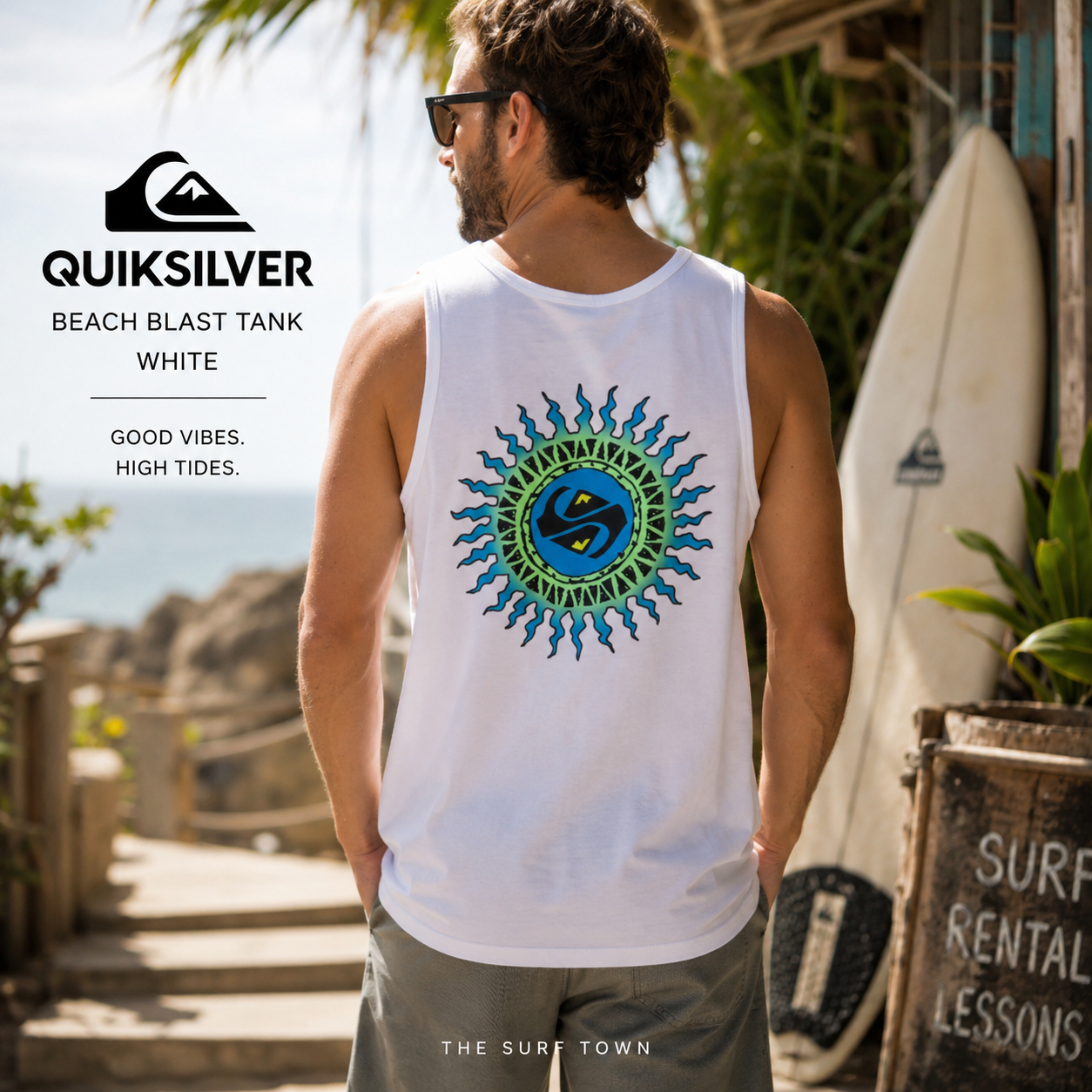 Camiseta Quiksilver Beach Blast Tank White para hombre en entorno surf tropical, fotografía editorial propia de THE SURF TOWN, camiseta de tirantes blanca con gráfico trasero inspirado en el surf y el verano.