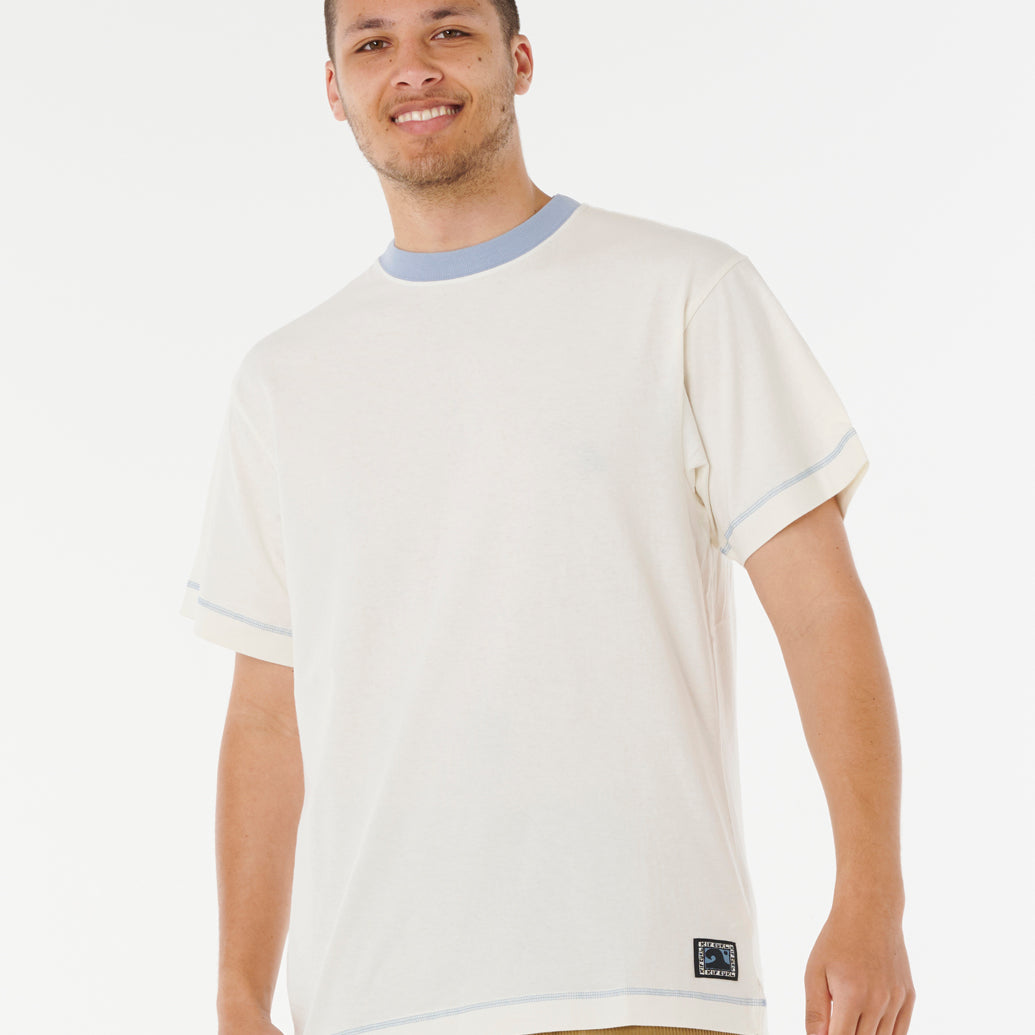 Camiseta Rip Curl Artist Ty Williams Spray Bone hombre color hueso con detalles azules, edición Artist Series y tejido 100% algodón transpirable