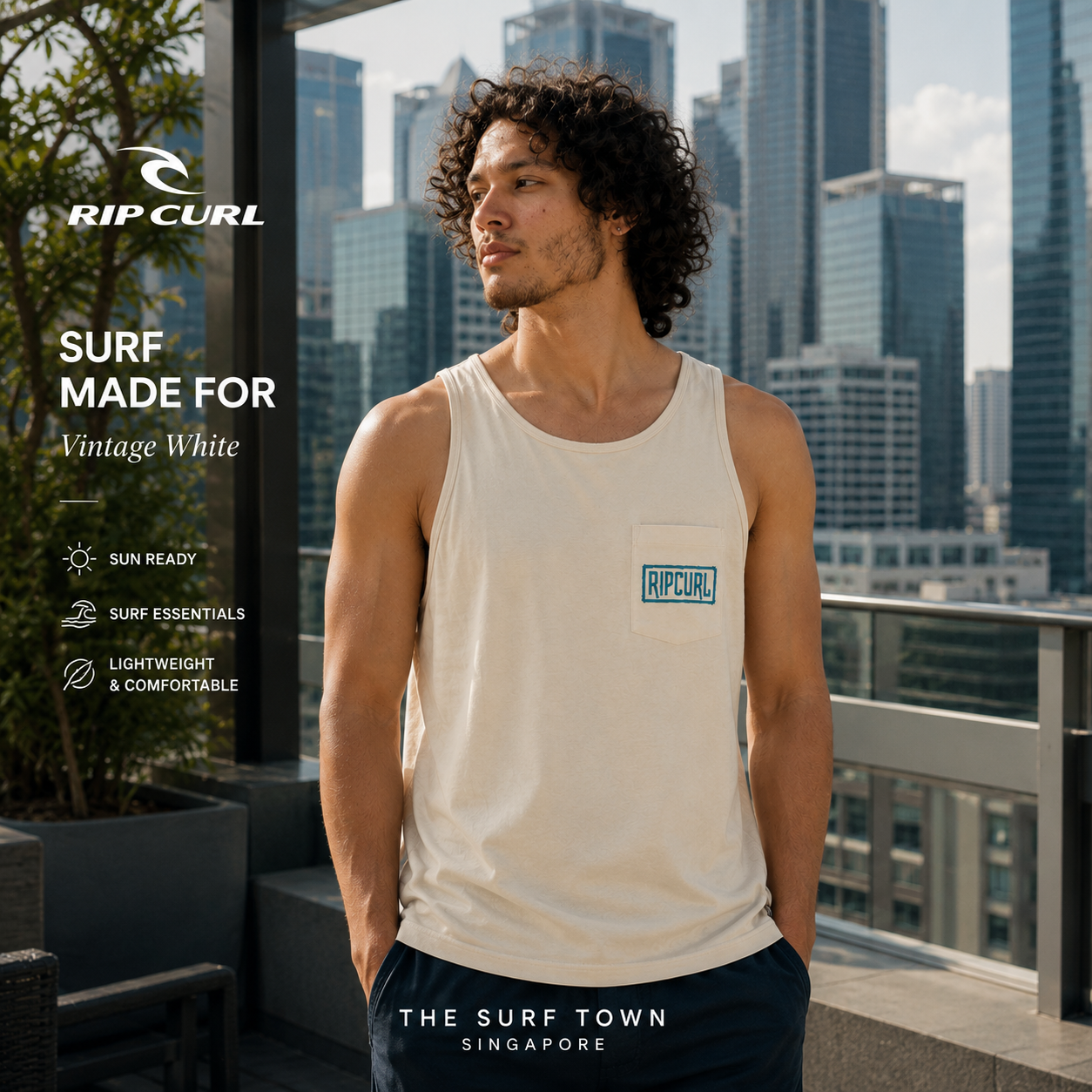 Fotografía propia de THE SURF TOWN de la camiseta de tirantes Rip Curl Surf Made For Tank Vintage White para hombre en un rooftop de Singapur con skyline urbano premium y ambiente surf lifestyle contemporáneo.