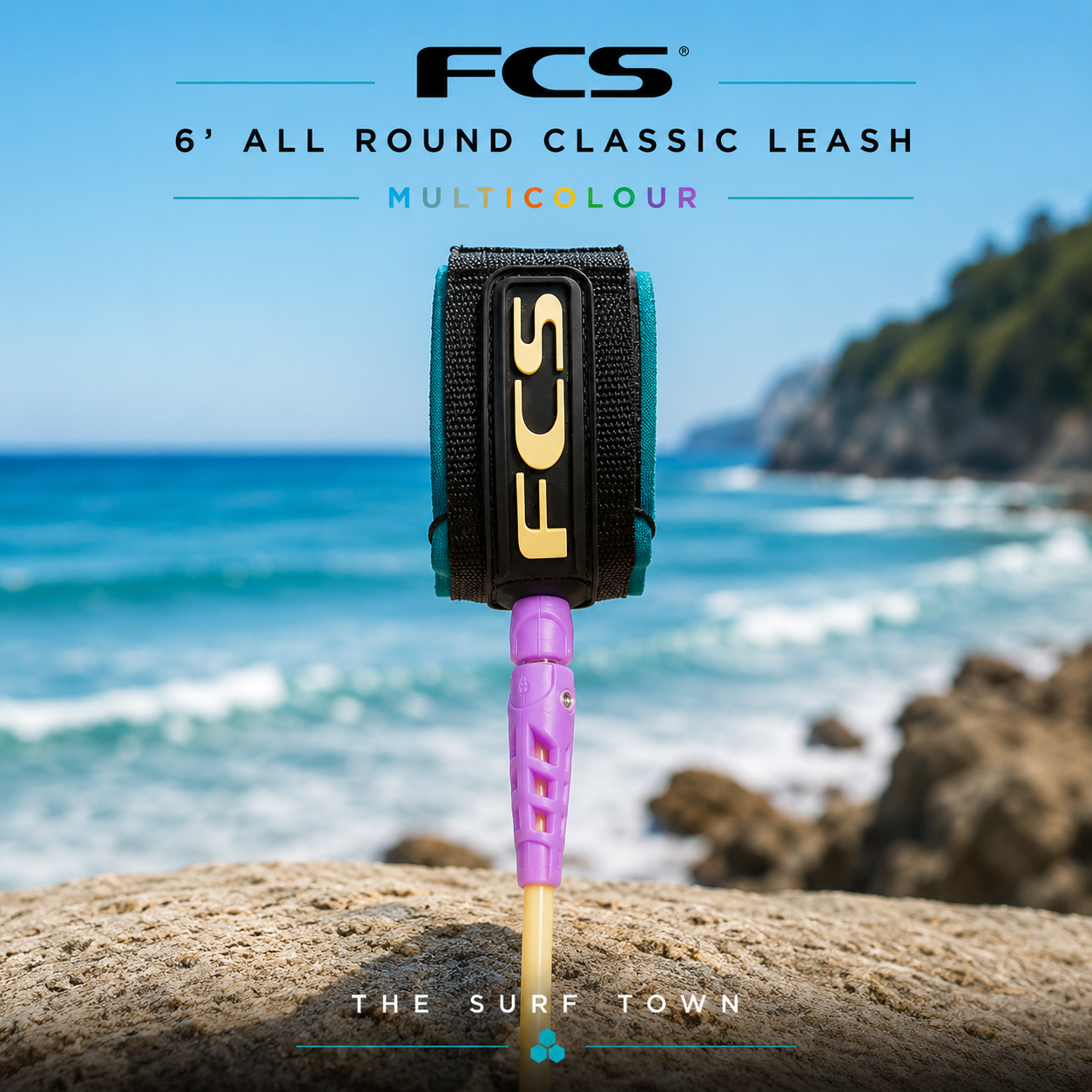Leash FCS 6' All Round Classic Leash Multicolour en fotografía editorial propia de THE SURF TOWN con ambiente surf premium, mar azul, luz solar diurna y fondo costero desenfocado para destacar el producto.