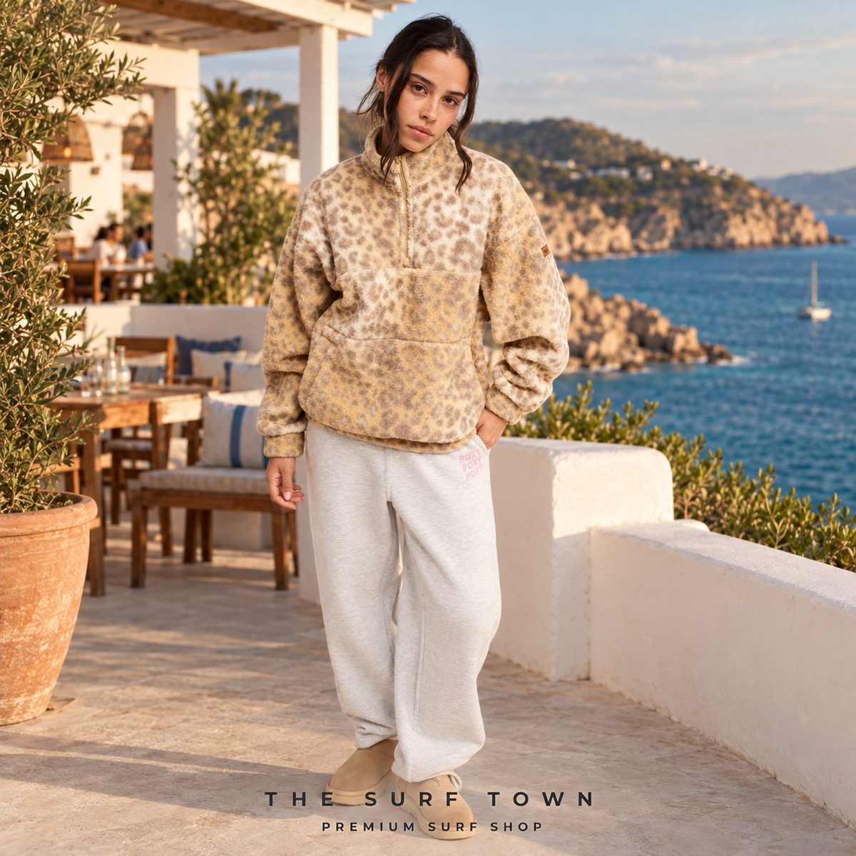 Imagen editorial propia de surf town de mujer con polar Roxy Jive Talking Bonded Wild Side beige de estampado leopardo junto al mar