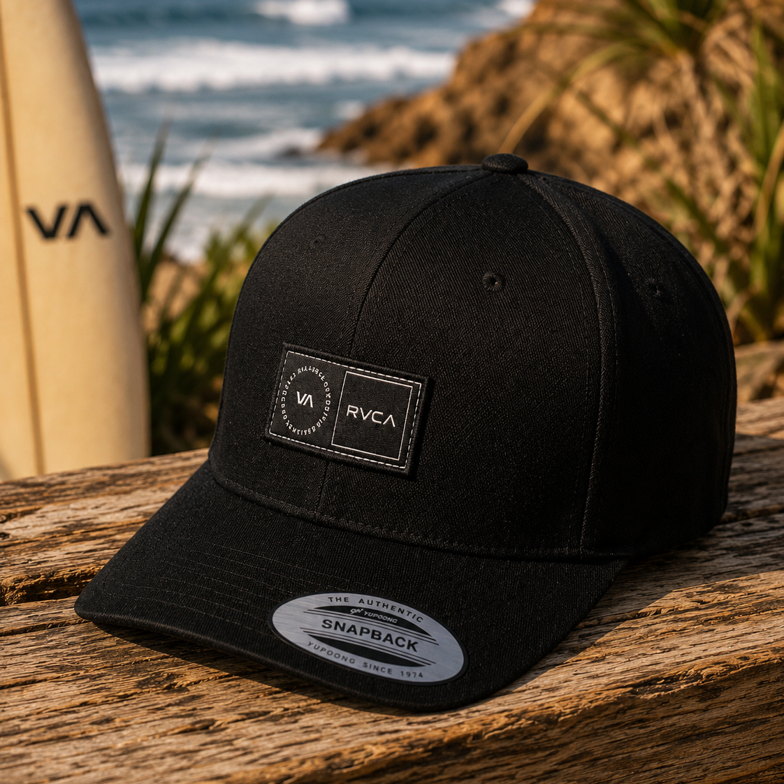 Gorra RVCA Platform negra estilo surf lifestyle sobre mesa de madera junto al mar
