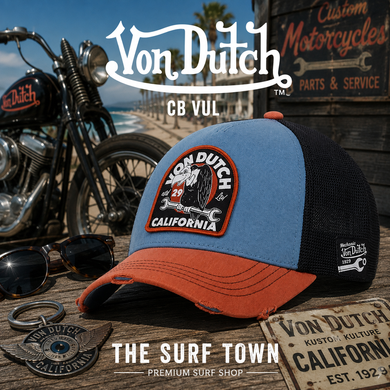 Gorra Von Dutch CB VUL en una fotografía editorial exclusiva creada por THE SURF TOWN con estética café racer, paseo marítimo costero y luz natural diurna, destacando el parche bordado California, el diseño trucker premium y la combinación de azul, negro y naranja.