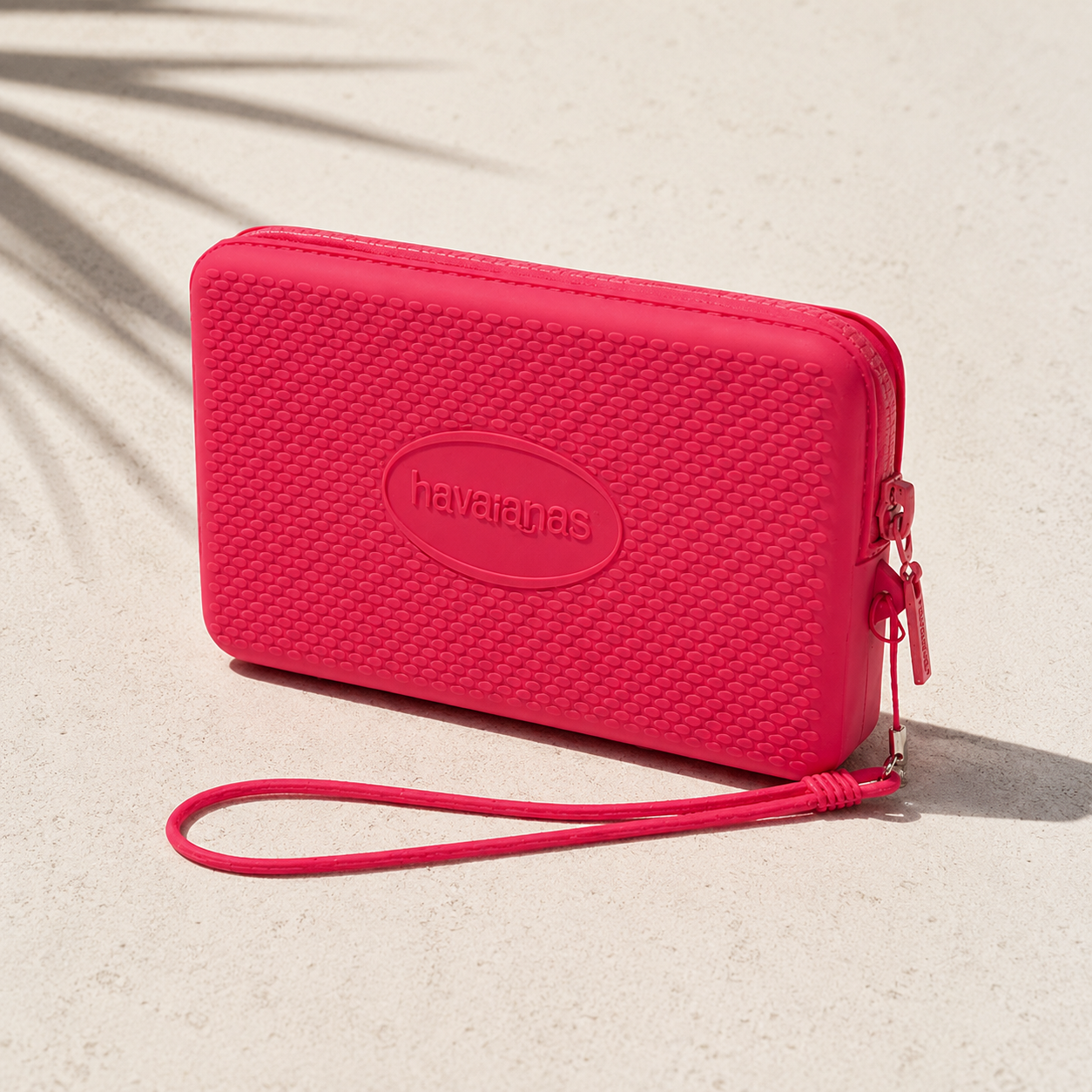 Bolsito Havaianas Mini Bag Pink Fever rosa sobre superficie mediterránea minimalista con sombras tropicales en ambiente beach lifestyle premium