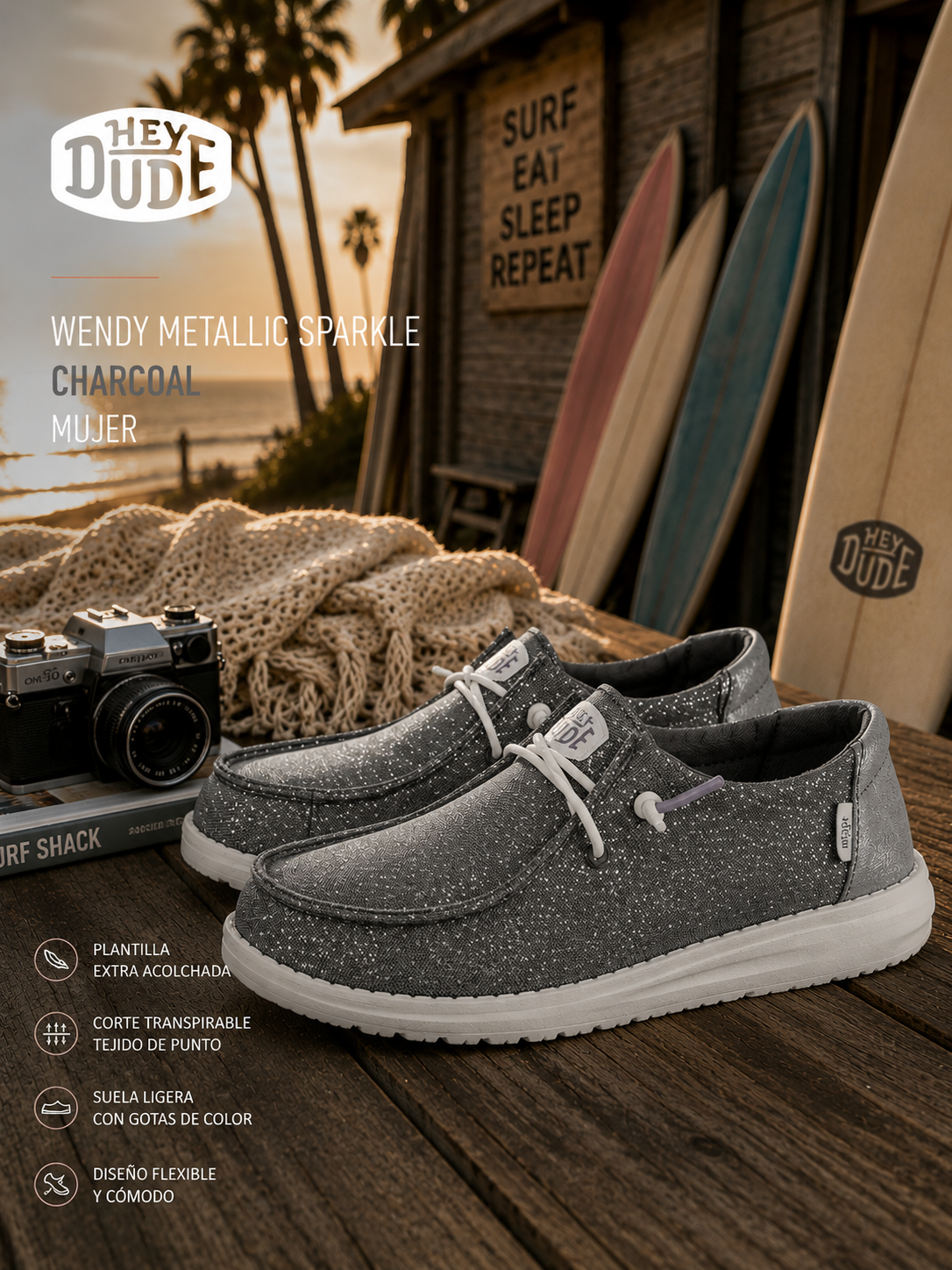 Zapatillas Hey Dude Wendy Metallic Sparkle Charcoal para mujer en escenario surf lifestyle premium con estética coastal cinema y luz dorada editorial