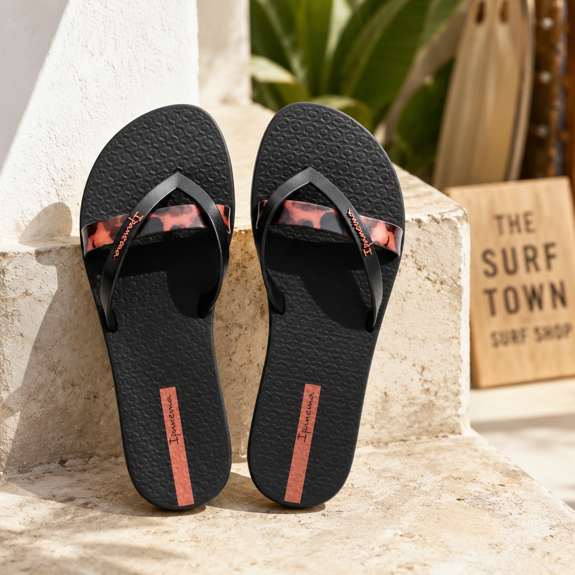 Chanclas Ipanema negras con detalle animal print en escenario coastal luxury mediterráneo premium