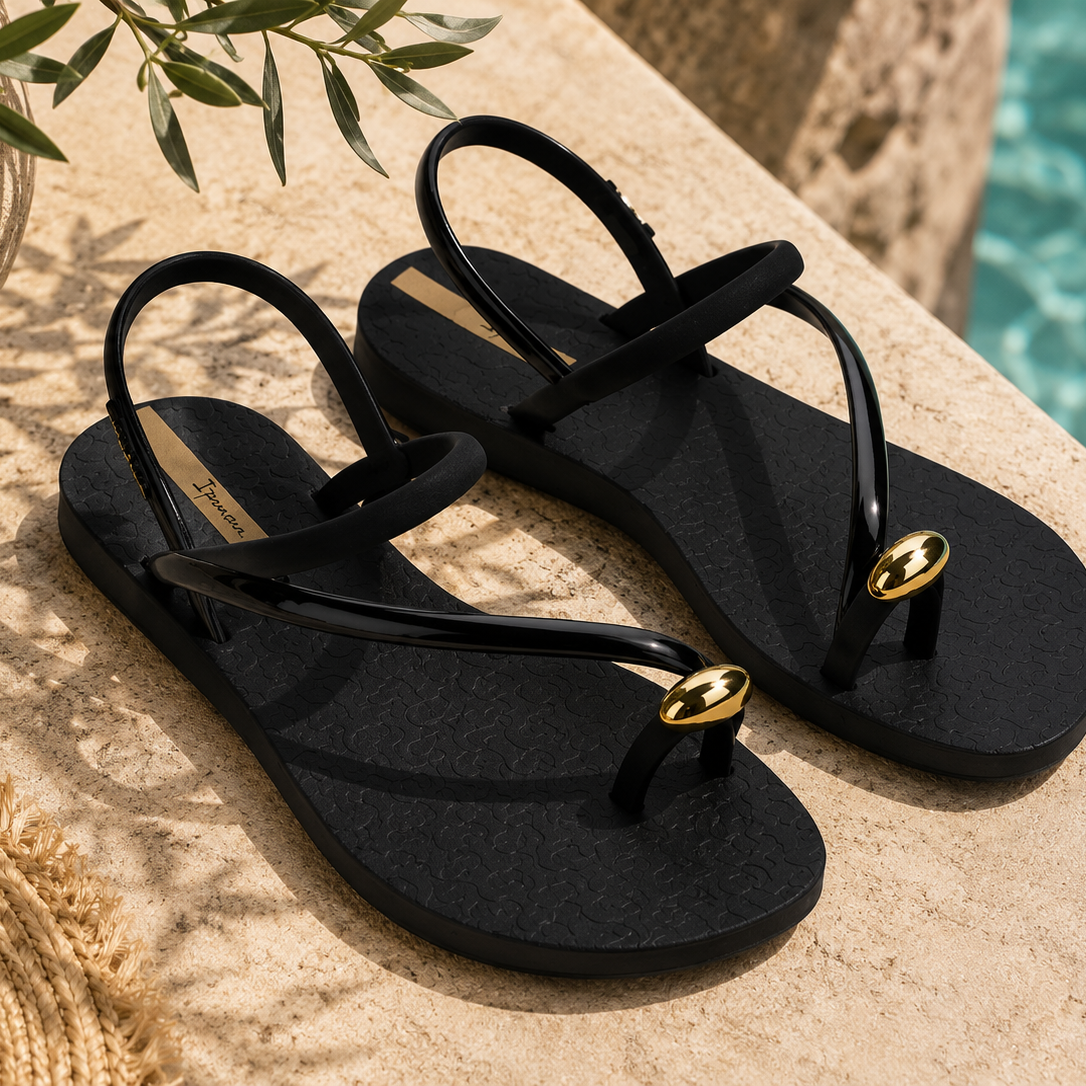 Sandalias Ipanema Glam Ring negras con detalle dorado en terraza mediterránea junto a piscina premium