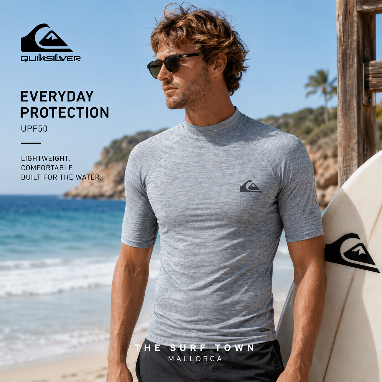 Licra Quiksilver Everyday UPF50 SS Quarry Heather en fotografía editorial propia de THE SURF TOWN junto al mar con tabla de surf y estilo surf performance premium bajo luz natural diurna