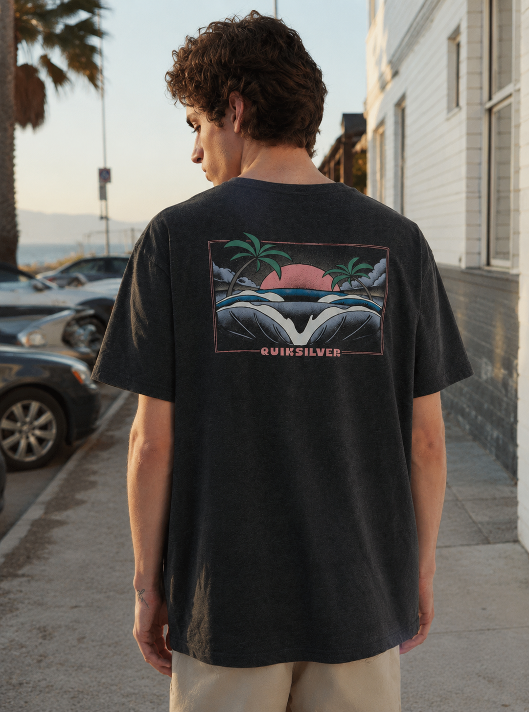 Camiseta Quiksilver Hellbender Black para hombre en escena surf street lifestyle junto al paseo marítimo al atardecer