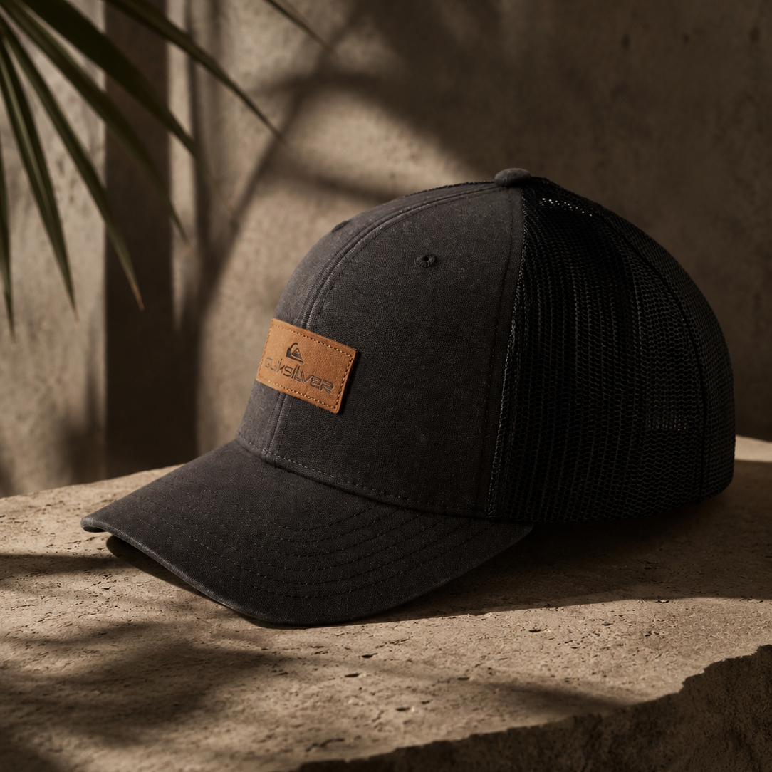 Gorra trucker Quiksilver negra Down Tech hombre estilo surf premium lifestyle sobre piedra natural tropical