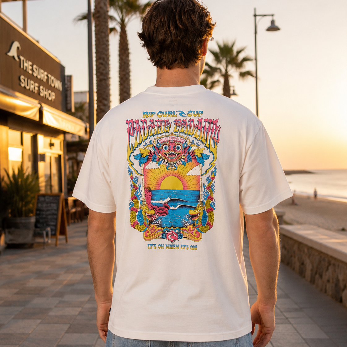 Camiseta blanca Rip Curl Padang Padang hombre en paseo marítimo surf lifestyle premium al atardecer Costa del Sol