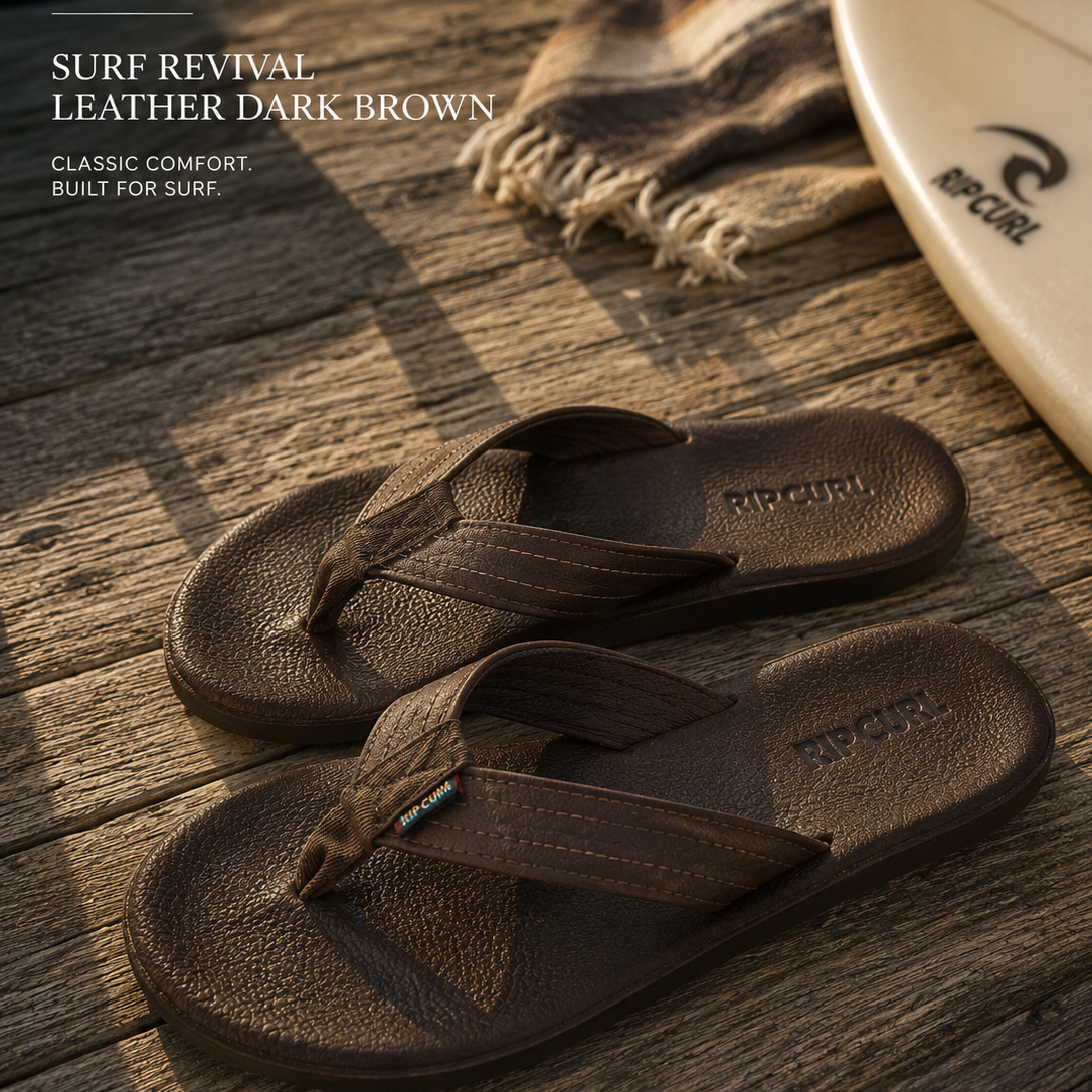 Sandalias Rip Curl Surf Revival Leather Dark Brown en escena surf lifestyle sobre madera frente al mar con luz natural cálida