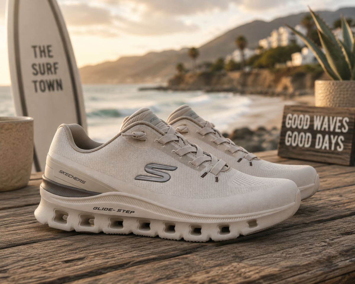 Zapatillas Skechers Glide Step Pro Taupe en escena lifestyle premium sobre mesa de madera junto al mar y ambiente surf Costa del Sol