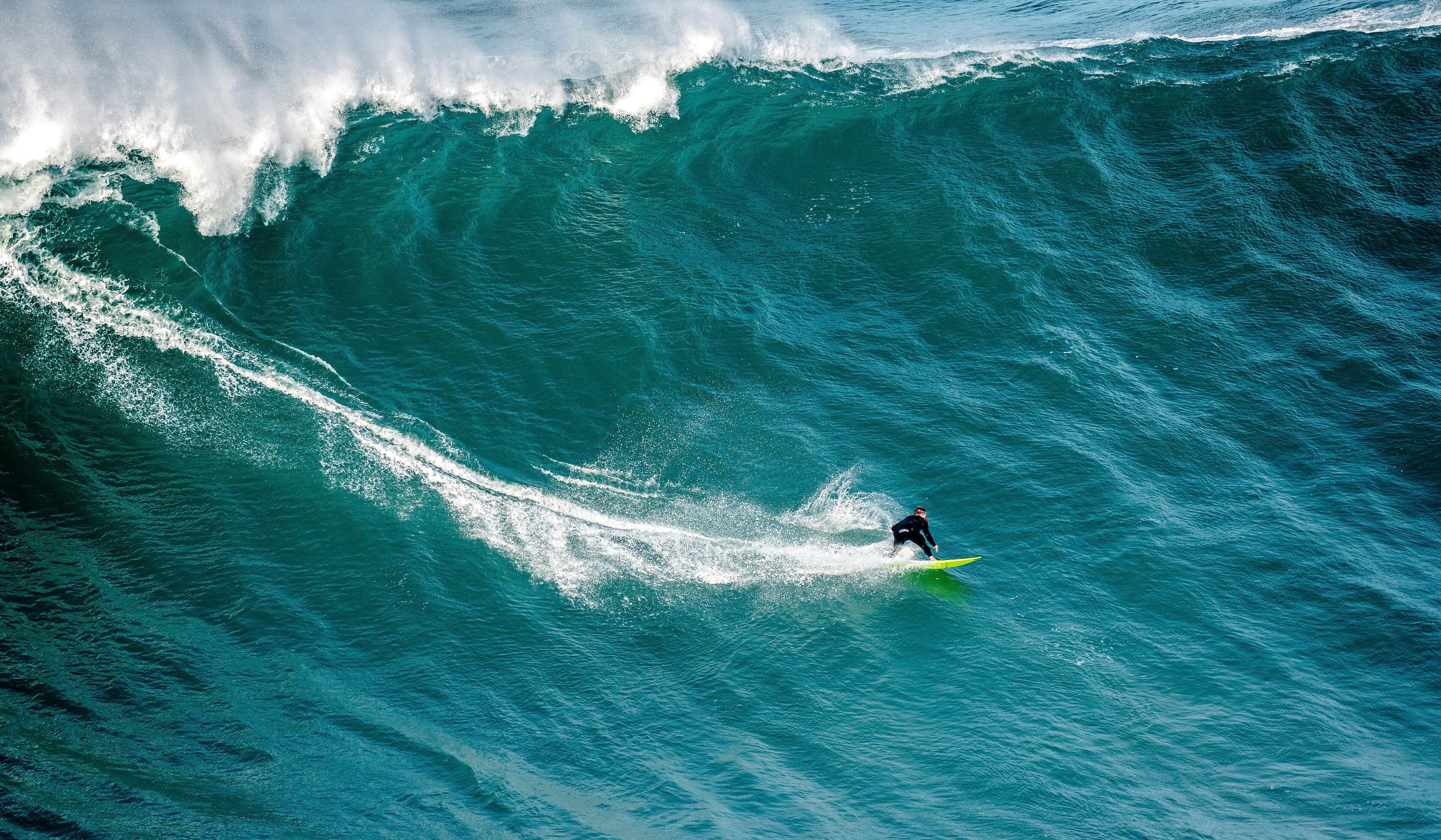 Surfista frente a una ola gigante en Nazaré, escenario clave de los Big Wave Challenge 2026
