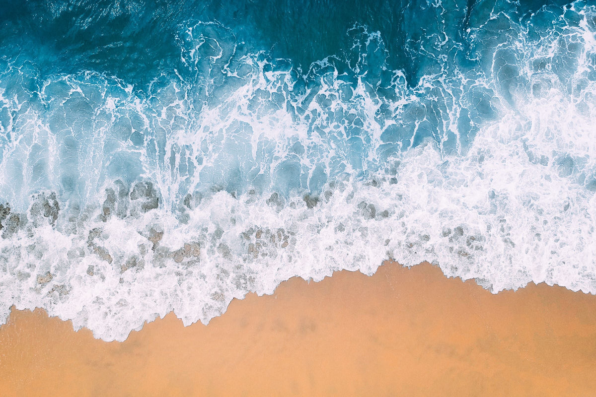 Vista aérea de olas y canales de agua junto a una playa